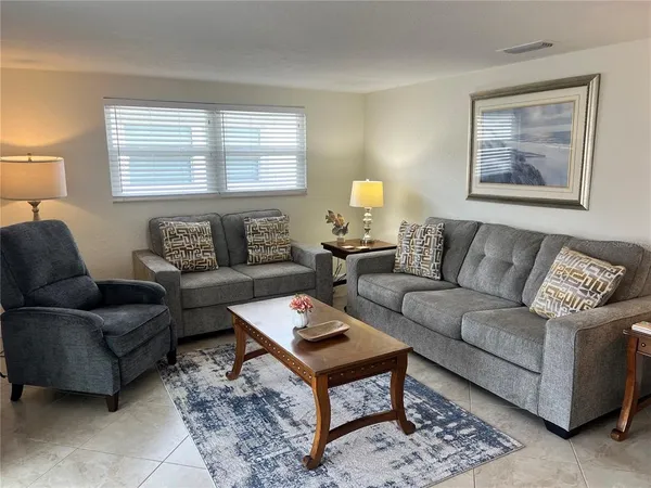a living room with furniture a couch and two windows