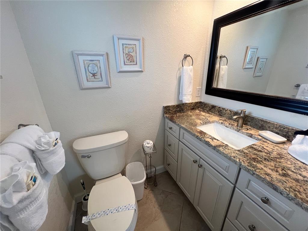 6154 Midnight Pass Road, Unit B07 Sarasota, FL 34242 - Photo 10 of 15 a bathroom with a granite countertop toilet sink and mirror