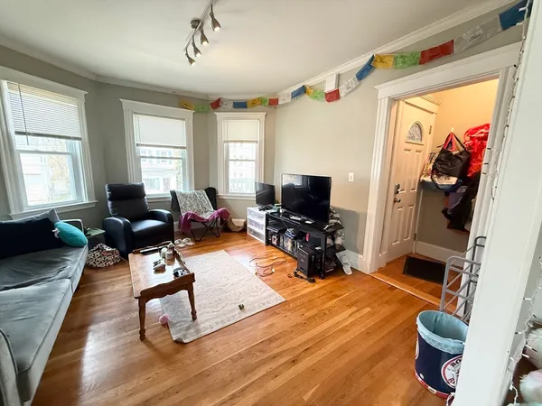 a living room with furniture a window and a flat screen tv