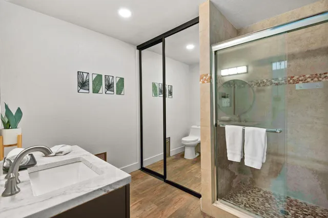 a bathroom with a sink a toilet and shower