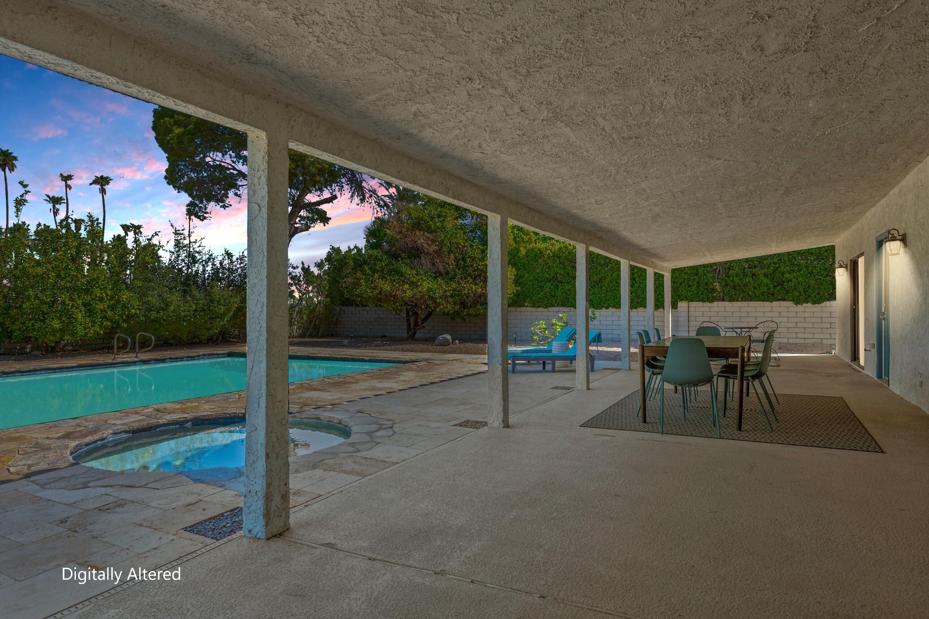3060 East Verona Road Palm Springs, CA 92262 - Photo 29 of 33 a view of a patio with a table chairs and a floor to ceiling window