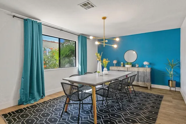 a kitchen with stainless steel appliances kitchen island granite countertop a dining table chairs and white cabinets