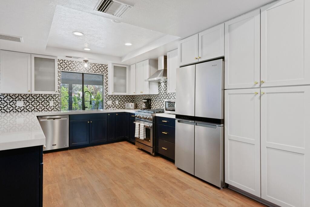 3060 East Verona Road Palm Springs, CA 92262 - Photo 9 of 33 a kitchen with a refrigerator a sink dishwasher with a dining table and chairs