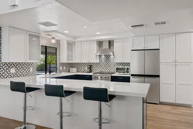 a kitchen with a refrigerator a sink dishwasher with a dining table and chairs