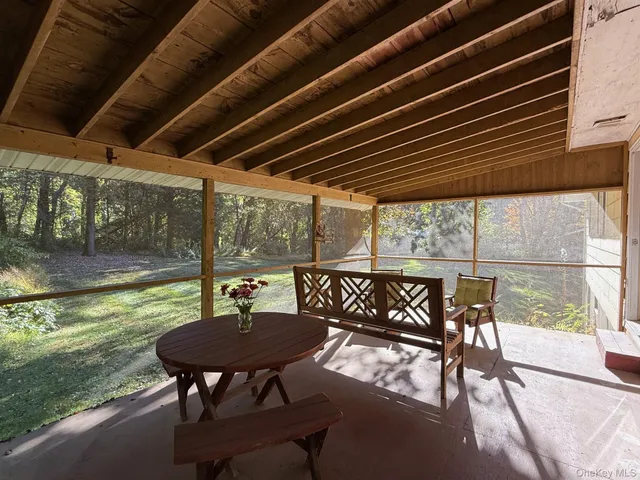 a view of a chairs and table in patio with a yard