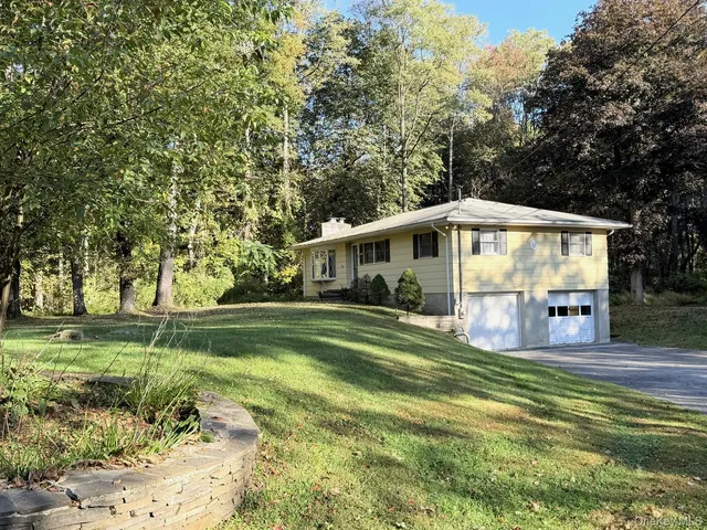 a front view of house with yard and green space