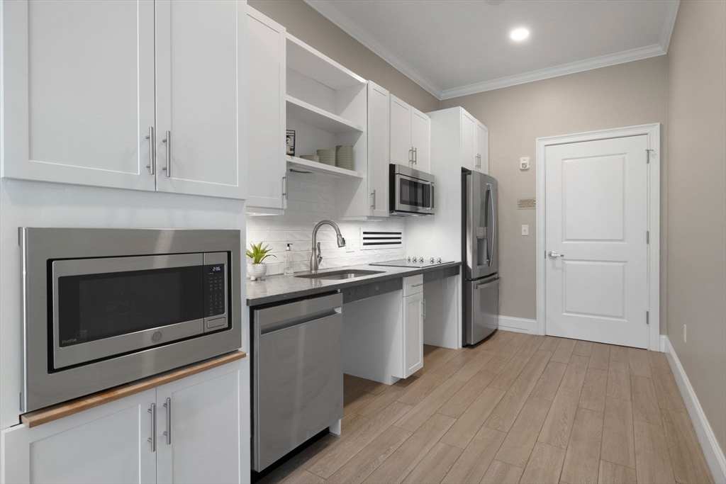 320 Middlesex Avenue, Unit B109 Medford, MA 02155 - Photo 18 of 21 a kitchen with stainless steel appliances granite countertop a stove a refrigerator and a microwave