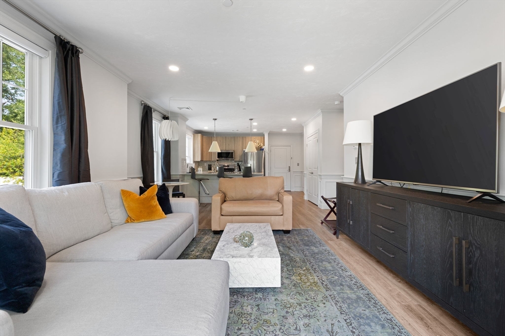 320 Middlesex Avenue, Unit B109 Medford, MA 02155 - Photo 5 of 21 a living room with furniture and a flat screen tv