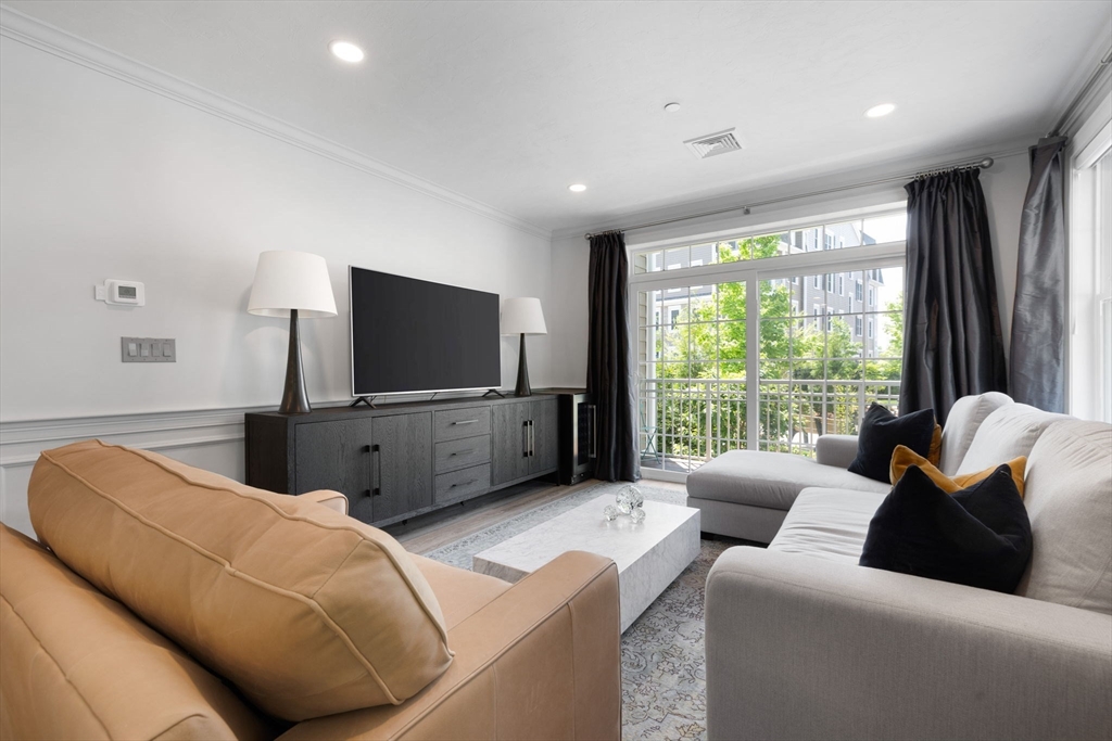 320 Middlesex Avenue, Unit B109 Medford, MA 02155 - Photo 6 of 21 a living room with furniture and a flat screen tv