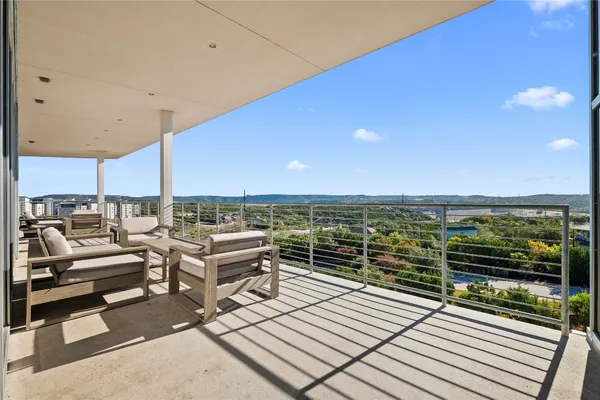 a view of a balcony with chairs and wooden floor