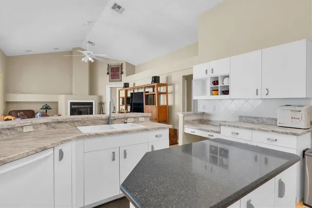 a kitchen with a stove a sink a refrigerator and cabinets