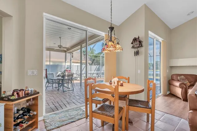 a view of a dining room and livingroom with furniture wooden floor a chandelier