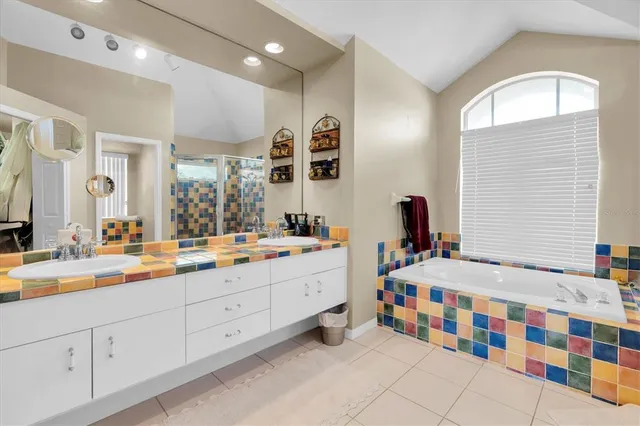 a bathroom with a double vanity sink mirror and bathtub