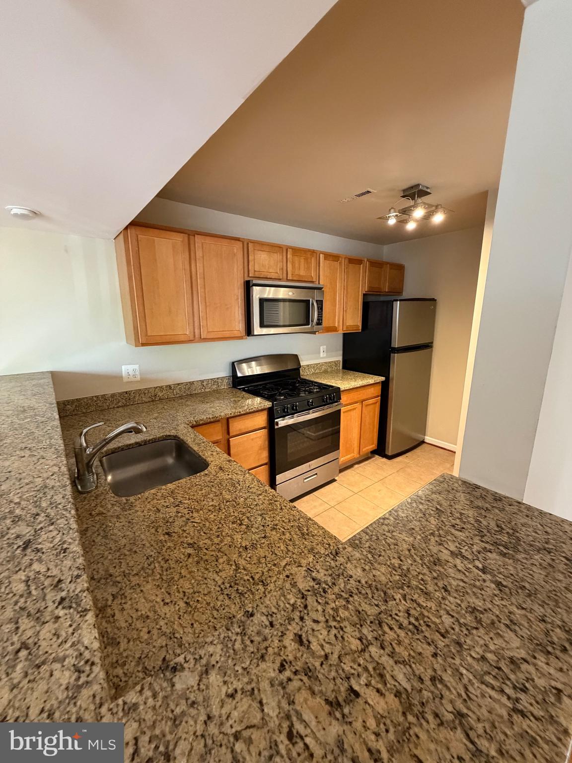 2514 Markham Lane, Unit 3 Landover, MD 20785 - Photo 9 of 13 a kitchen with stainless steel appliances granite countertop a stove a sink and a microwave
