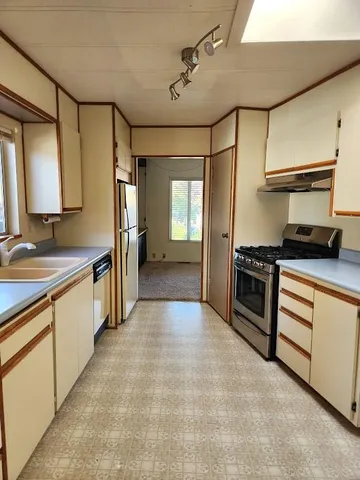 a kitchen that has a sink and stainless steel appliances