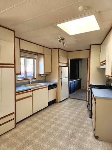 a view of a kitchen with stainless steel appliances granite countertop a stove and a refrigerator