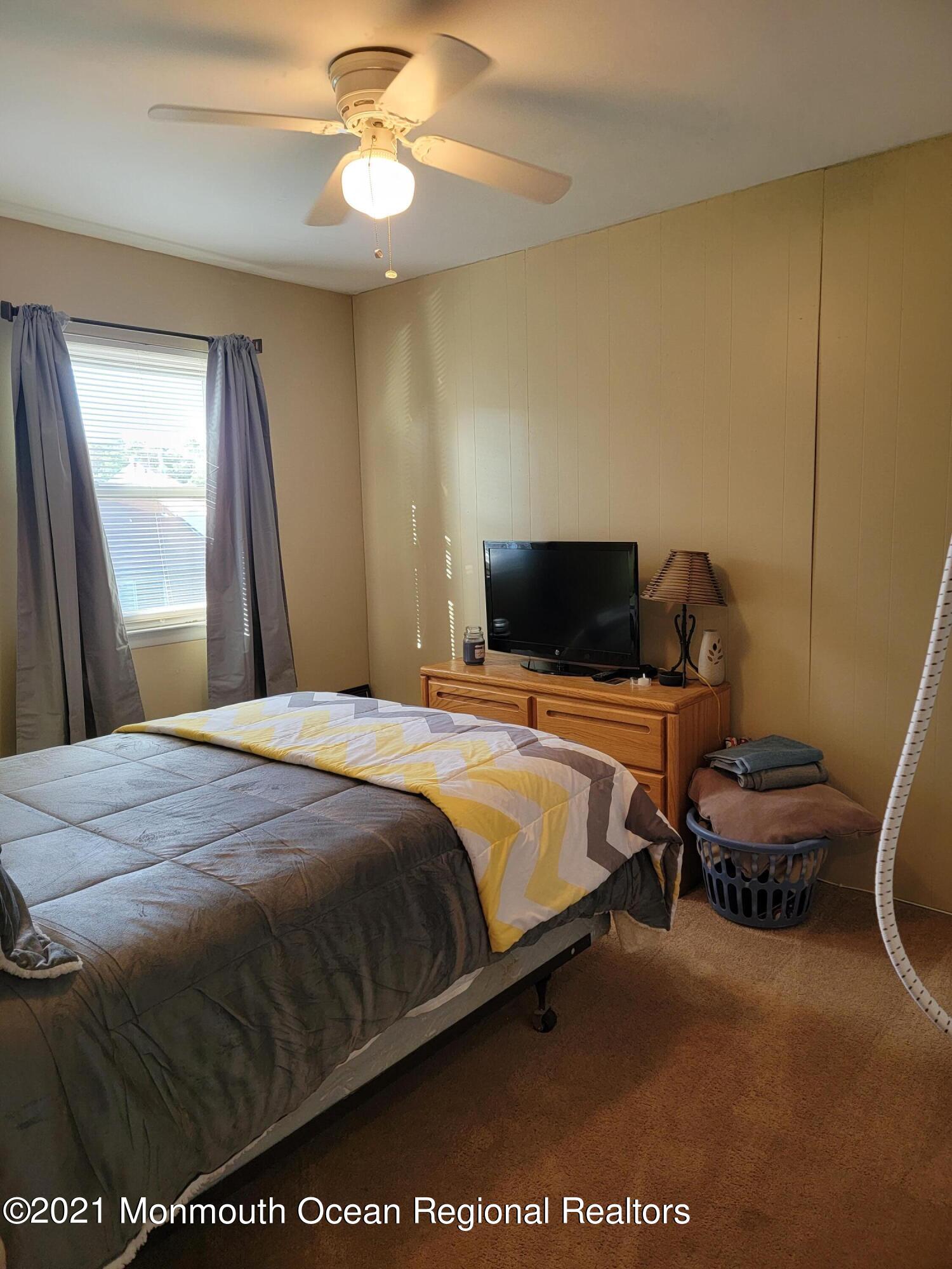 76 Greenwood Loop Road Brick, NJ 08724 - Photo 17 of 24 a bedroom with a bed and a chandelier