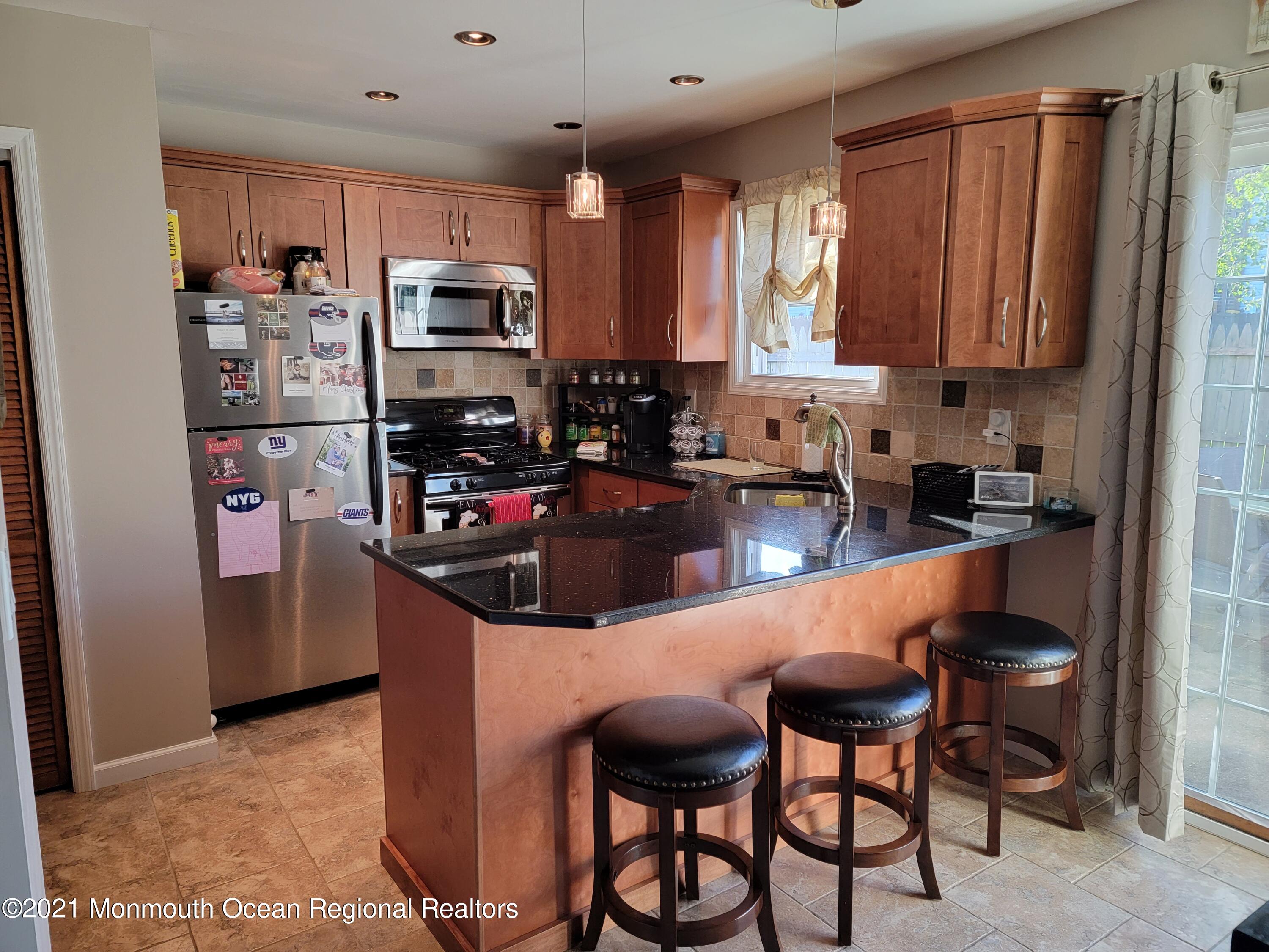 76 Greenwood Loop Road Brick, NJ 08724 - Photo 2 of 24 a kitchen with stainless steel appliances granite countertop a stove top oven a refrigerator a sink and dishwasher