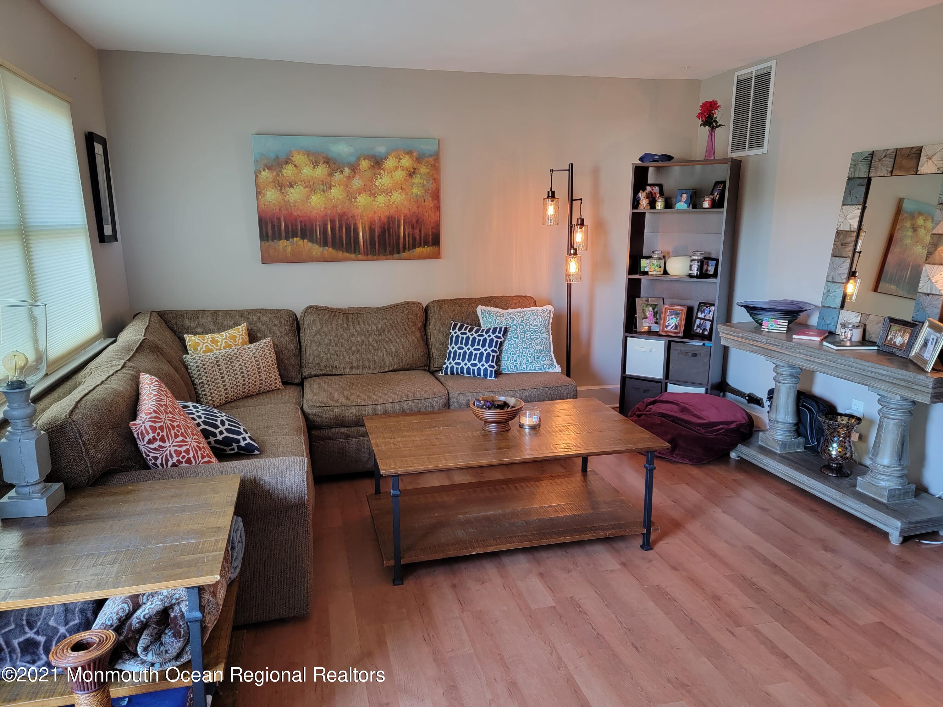 76 Greenwood Loop Road Brick, NJ 08724 - Photo 5 of 24 a living room with furniture a flat screen tv and a fireplace
