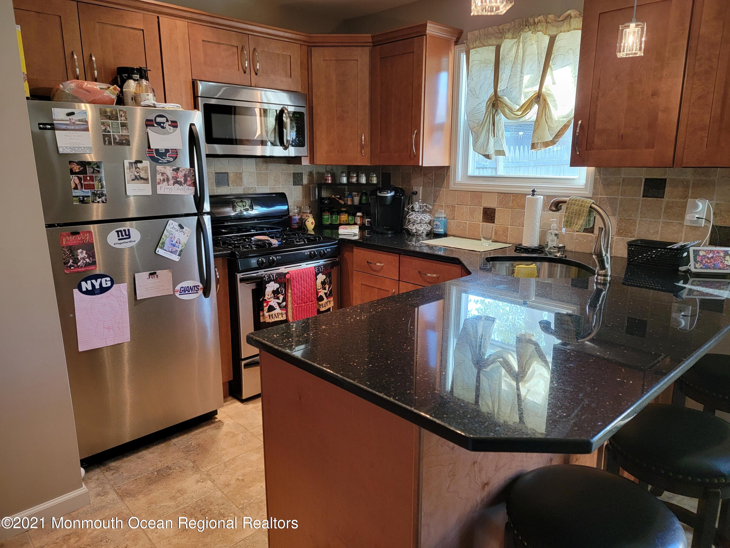 76 Greenwood Loop Road Brick, NJ 08724 - Photo 8 of 24 a kitchen with stainless steel appliances granite countertop a sink stove and refrigerator