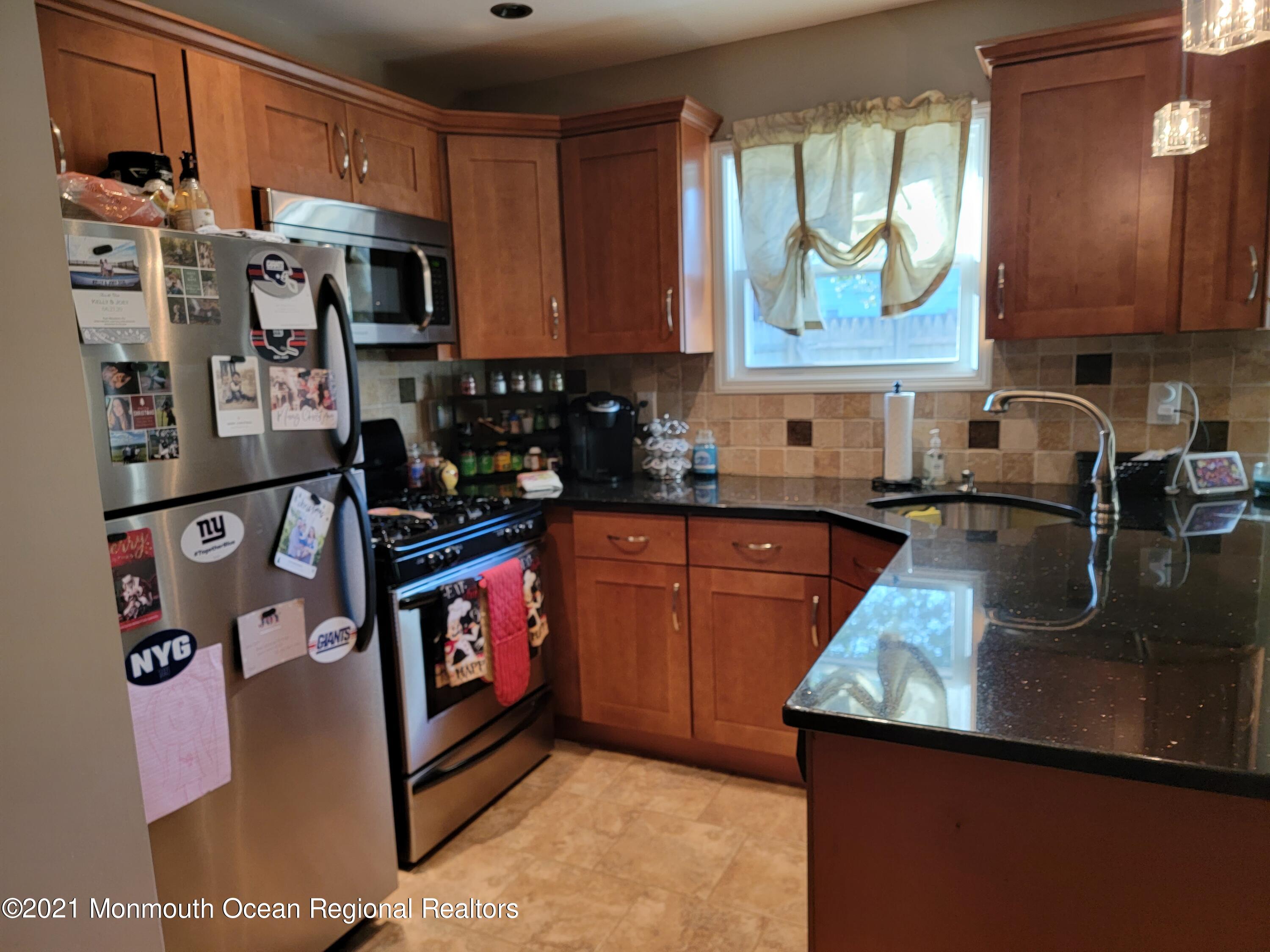 76 Greenwood Loop Road Brick, NJ 08724 - Photo 10 of 24 a kitchen with stainless steel appliances granite countertop a refrigerator a stove top oven a sink and dishwasher
