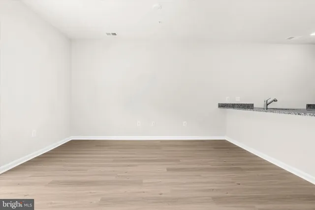 a kitchen with granite countertop a sink white cabinets with a large window