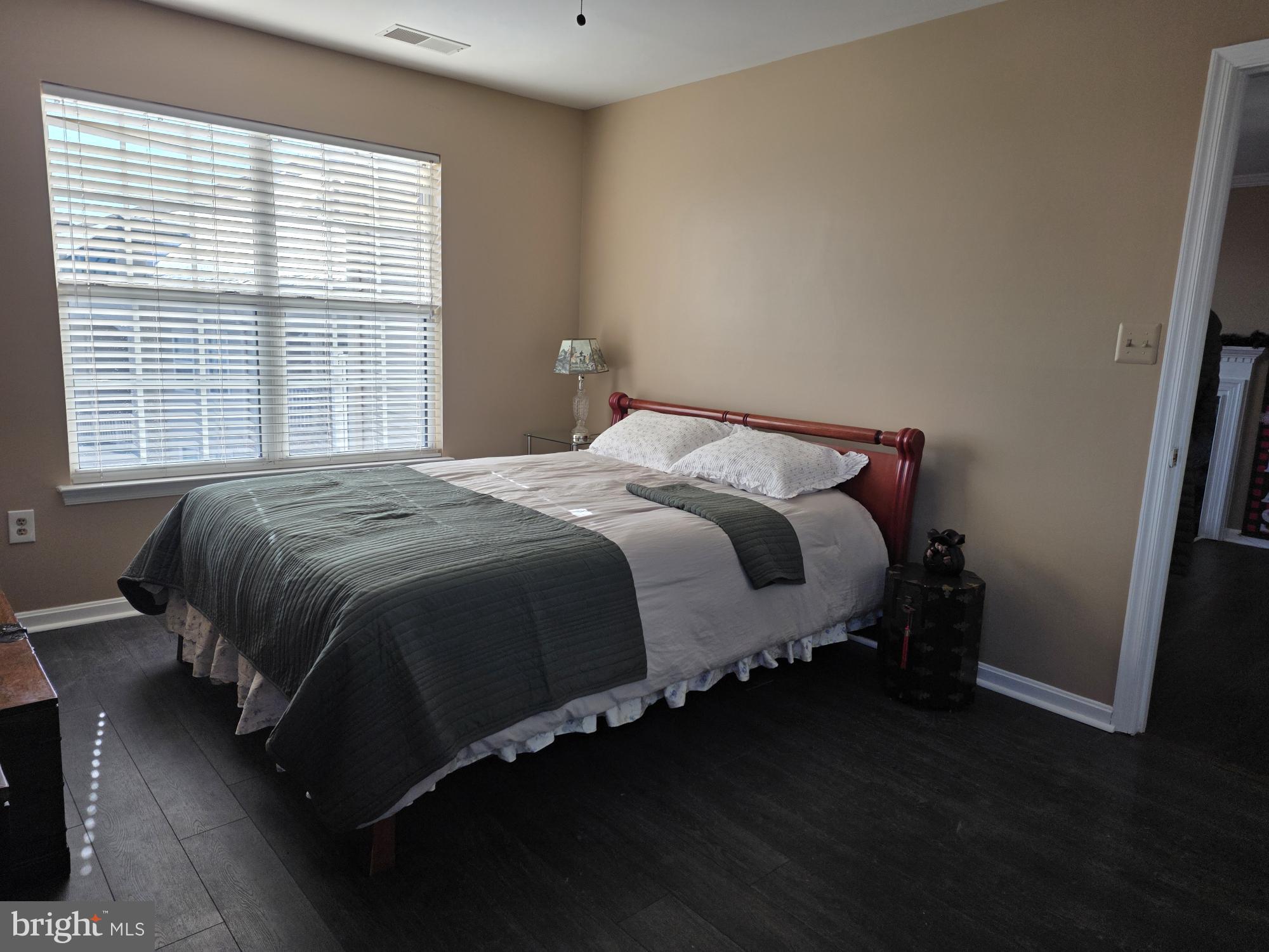 1037 Gardenview Loop, Unit 302 Woodbridge, VA 22191 - Photo 7 of 14 a bed sitting in a bedroom next to a window