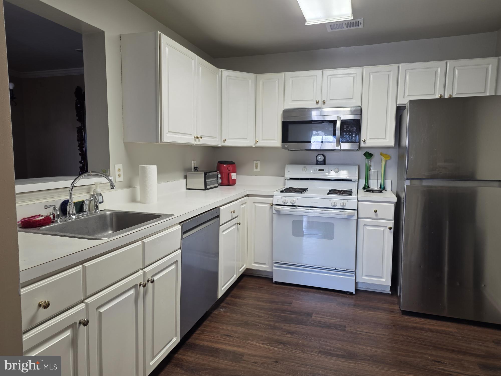 1037 Gardenview Loop, Unit 302 Woodbridge, VA 22191 - Photo 10 of 14 a kitchen with white cabinets and white appliances