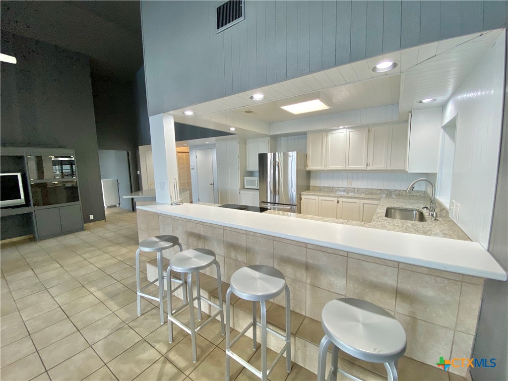 906 Lakeview Trail McQueeney, TX 78123 - Photo 4 of 13 a large white kitchen with a sink and chairs