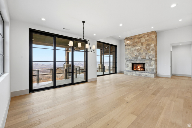 2155 East Wrangler Road Kamas, UT 84036 - Photo 34 of 62 Unfurnished living room with suspended lighting, a stone fireplace, and light wood-style floors