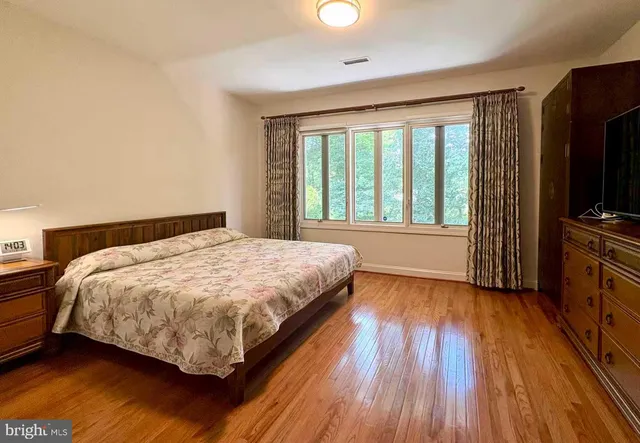 a spacious bedroom with a bed and a flat screen tv