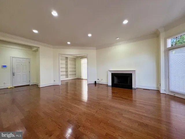 an empty room with wooden floor and fireplace