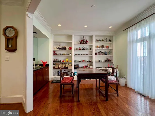 a room with stainless steel appliances wooden floor dining table and chairs
