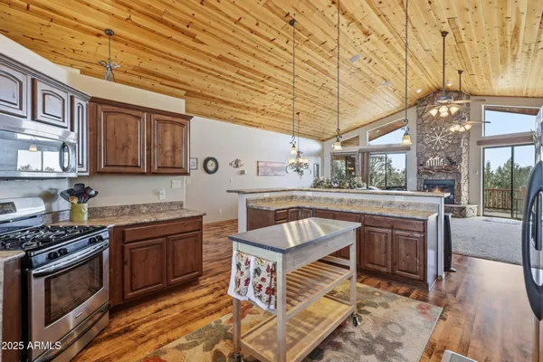 a kitchen with stainless steel appliances granite countertop a stove a sink and a wooden cabinets