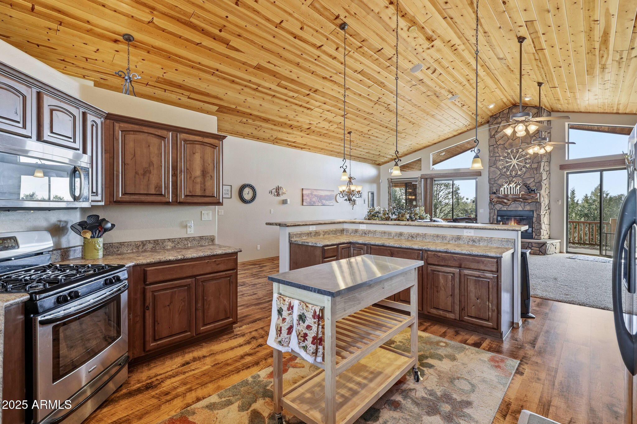 2276 Thunderbird Way Overgaard, AZ 85933 - Photo 11 of 41 a kitchen with stainless steel appliances granite countertop a stove a sink and a wooden cabinets