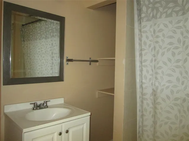 a view of a room with a chandelier fan and closet area