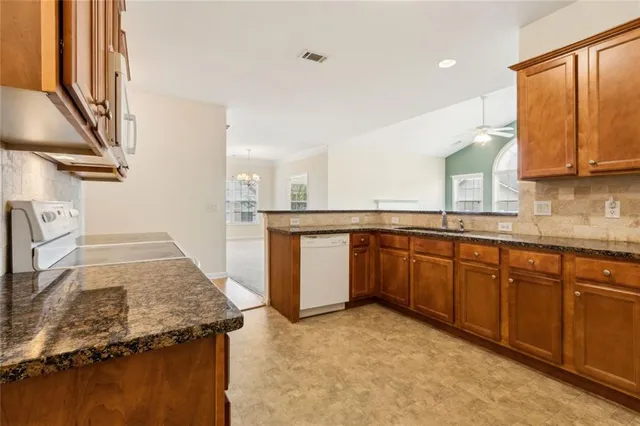 a kitchen with stainless steel appliances granite countertop a sink and a stove