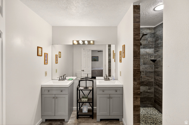 161 West 950 South, Unit Q1 St. George, UT 84770 - Photo 17 of 37 Bathroom featuring a walk in shower, two vanities, and a textured ceiling