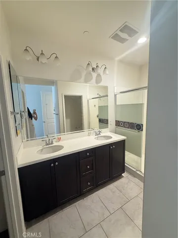 a spacious bathroom with a double vanity sink and mirror