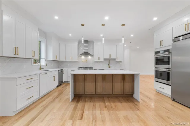 a large kitchen with stainless steel appliances granite countertop a large counter top a sink and a dishwasher