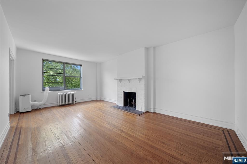 100 East Palisade Avenue, Unit B51 Englewood, NJ 07631 - Photo 2 of 37 a view of empty room with wooden floor and fireplace