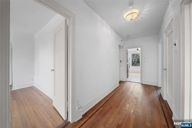a view of a hallway with wooden floor