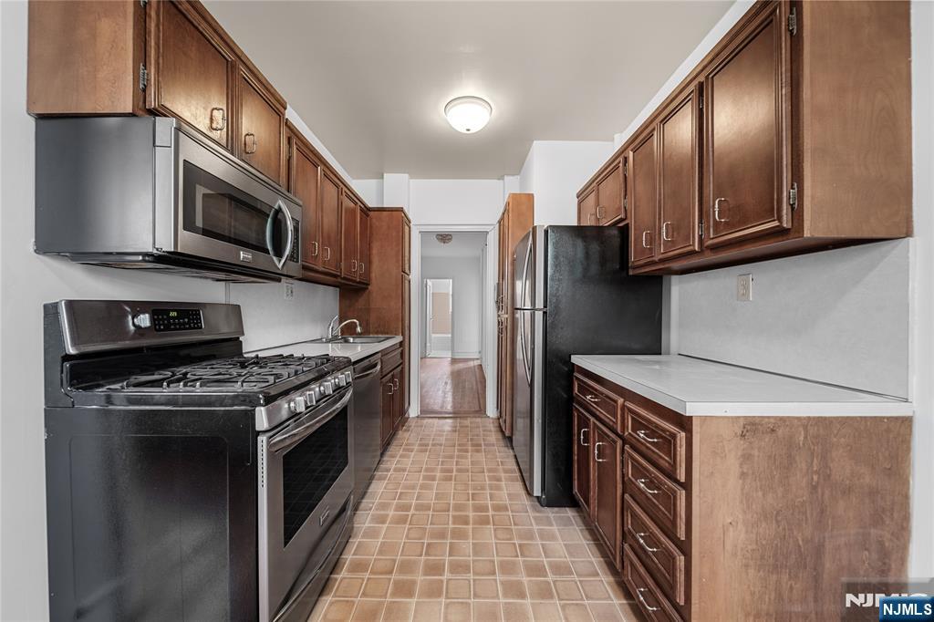 100 East Palisade Avenue, Unit B51 Englewood, NJ 07631 - Photo 9 of 37 a kitchen with stainless steel appliances granite countertop a stove a microwave and a refrigerator