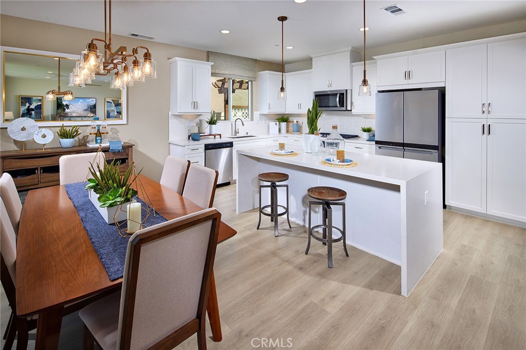 30952 Campania Road Highland, CA 92346 - Photo 7 of 27 a kitchen with kitchen island a stove a dining table and chairs