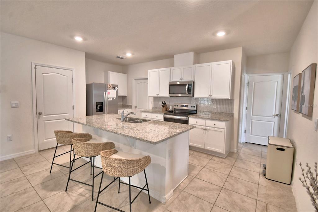 2839 Moulin Road Davenport, FL 33837 - Photo 13 of 75 a kitchen with stainless steel appliances a refrigerator sink and cabinets