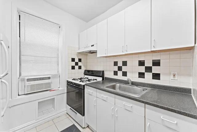 a kitchen with granite countertop white cabinets and white appliances
