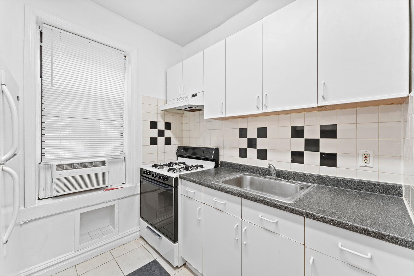 35-39 51st Street, Unit A4 Weehawken, NJ 07086 - Photo 5 of 16 a kitchen with granite countertop white cabinets and white appliances