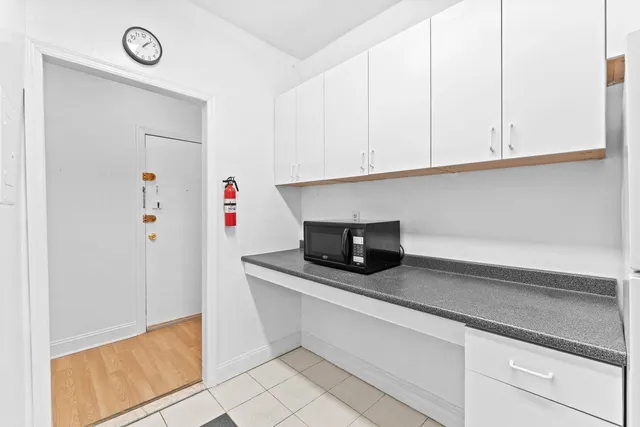 a kitchen with white cabinets and white appliances