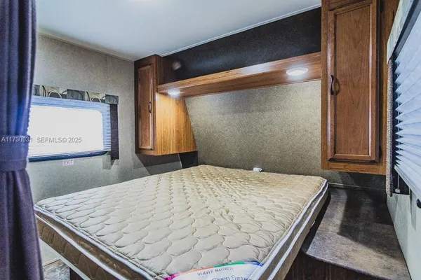 a bed sitting in a bedroom next to a window