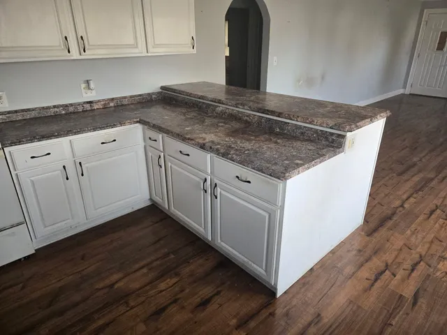 a kitchen with granite countertop a sink and cabinets